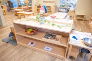 A classroom with light wood floors and several bookshelves